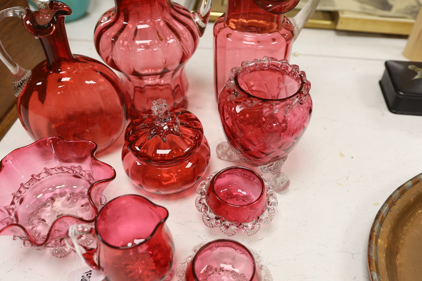 Two tall Victorian cranberry glass jugs, a decanter, a powder bowl ad four other items, tallest item decanter and stopper 27 cms high.